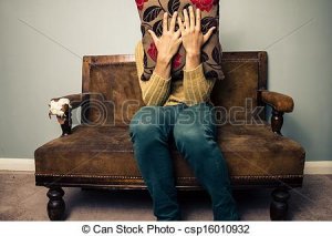 nervous-young-man-on-couch-hiding-behind-stock-photos_csp16010932.jpg